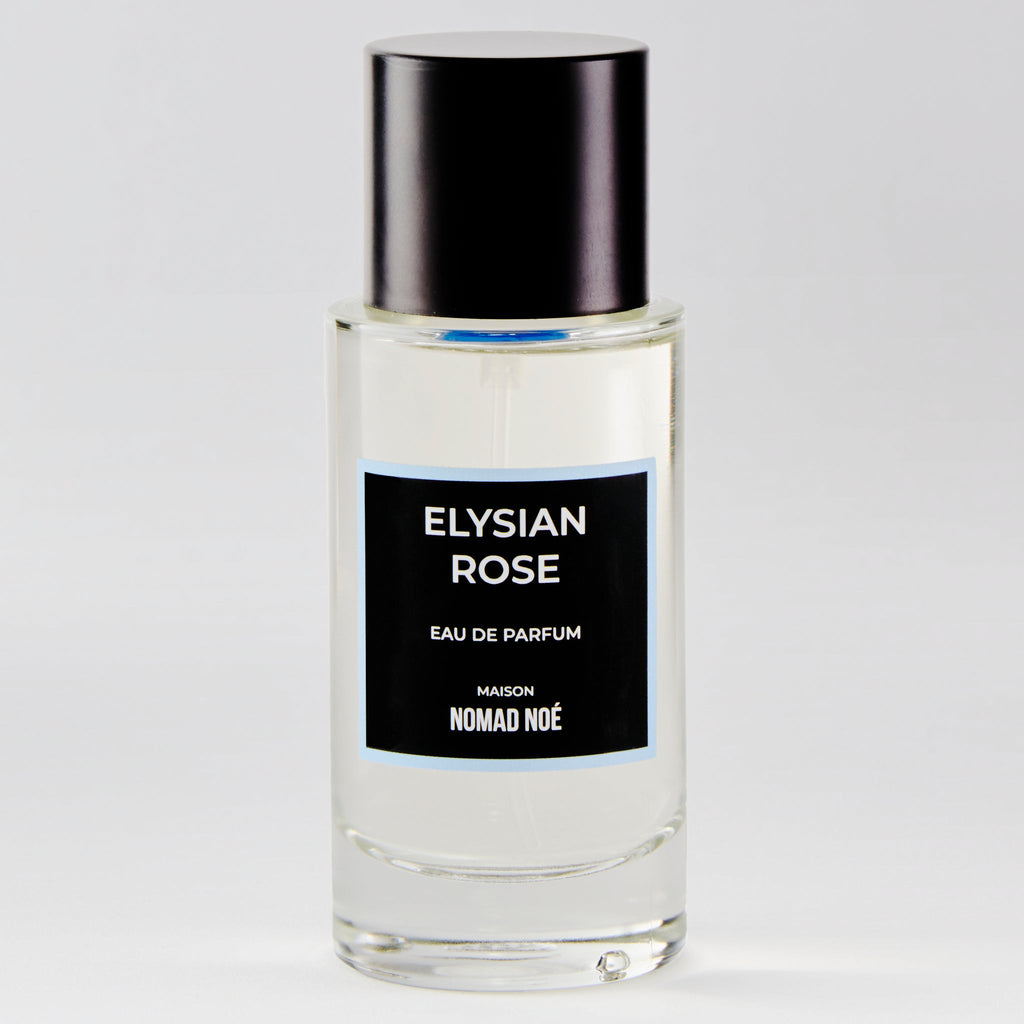 A clear bottle of Elysian Rose by Nomad Noe, featuring a black cap and label, exudes a modern rose scent.