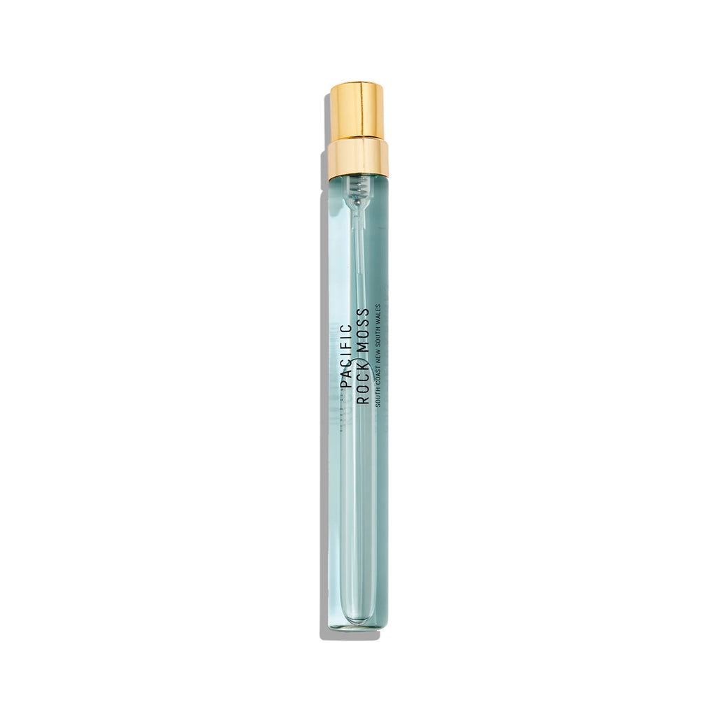 A slim, cylindrical perfume bottle with a gold cap and light blue liquid labeled "Pacific Rock Moss" by Goldfield & Banks, this fresh perfume captures the essence of beach life.
