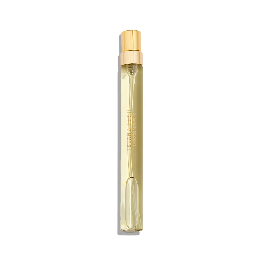 A slender, transparent glass perfume bottle with a gold spray top, filled with a light yellow liquid exuding an exotic fragrance reminiscent of South Pacific Sandalwood. The product is called Island Lush by Goldfield & Banks.