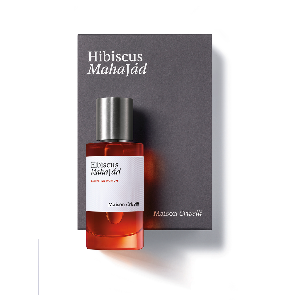 A bottle of Hibiscus Mahajád by Maison Crivelli rests in front of its gray box, both displaying the product's name and brand. This exquisite floral oriental fruity perfume highlights the key raw materials that make it truly unique.