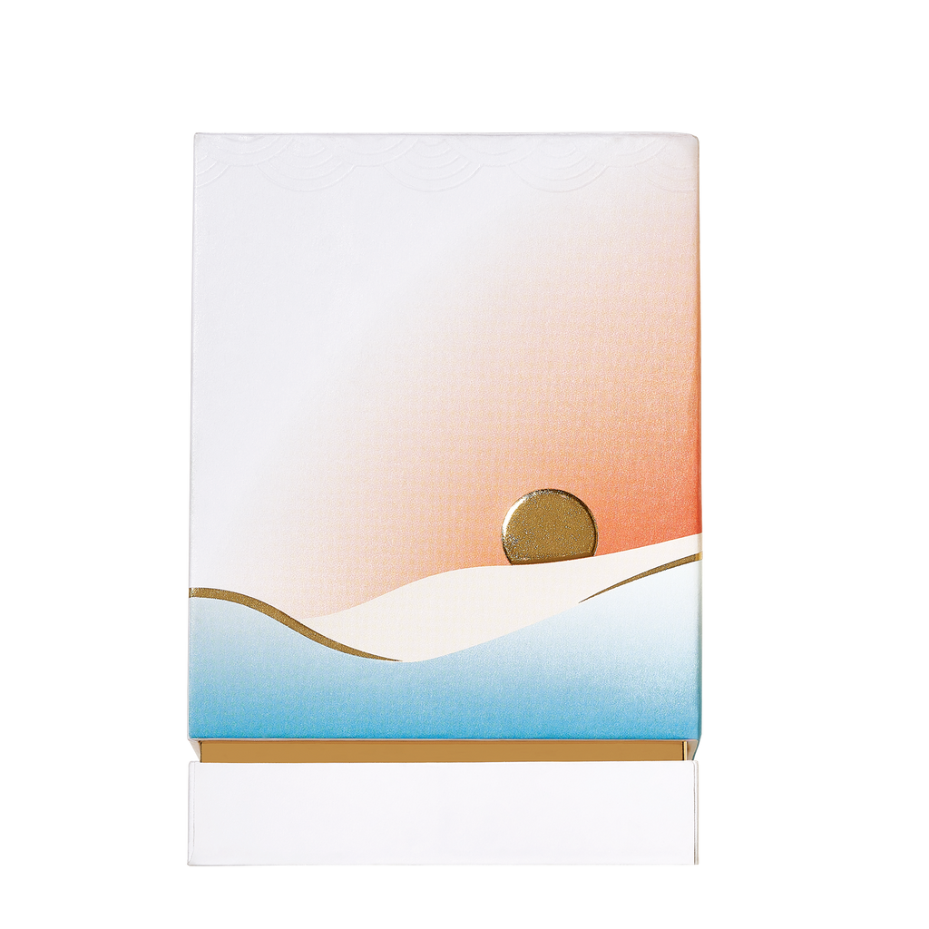 The Roja Parfums' Isola Sol captures the serene beauty of a summer holiday with its minimalist illustration of a setting sun over abstract dunes in white, blue, and gradient orange tones on a white background.