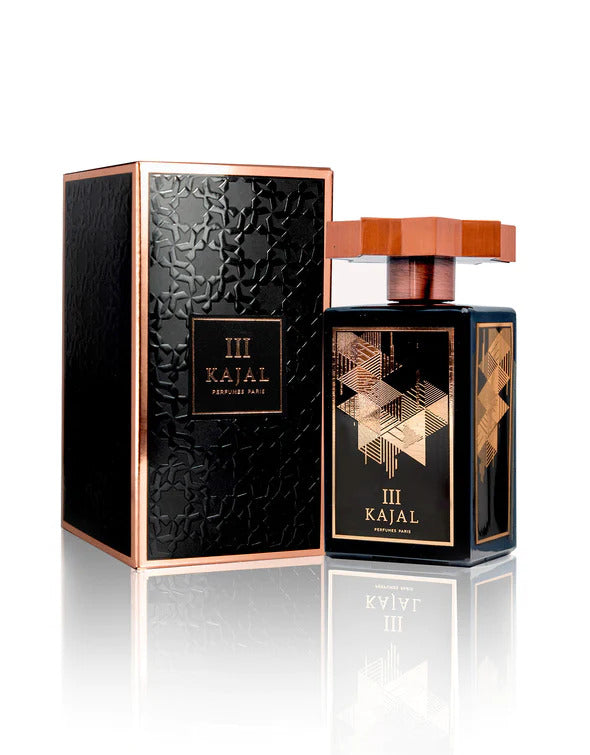 A bottle of Kajal III EDP from the Kajal - Classic Collection stands beside its rectangular black and gold textured packaging, embodying a blend of elegance and determination.