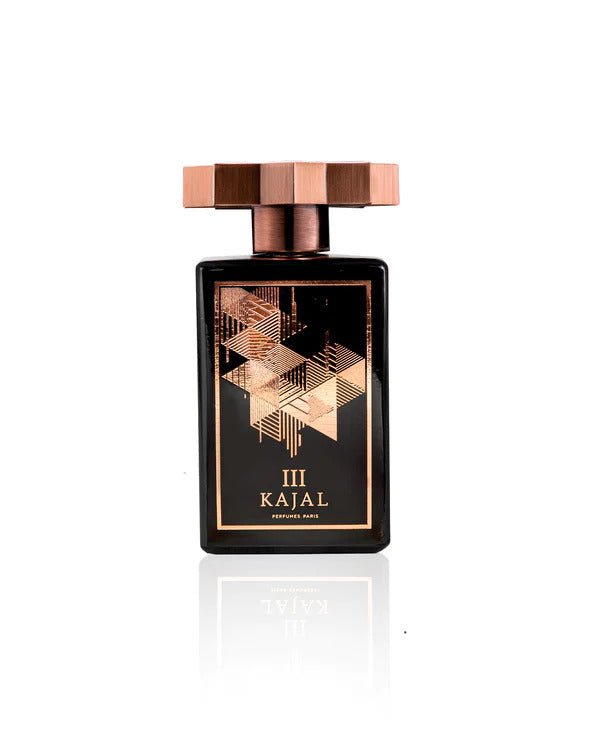 A black perfume bottle with a geometric patterned gold label, named "Kajal III EDP" from the Kajal - Classic Collection, featuring a rectangular bronze cap with an angular design that reflects determination and courage.