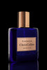 A dark blue, rectangular perfume bottle with a copper cap and a label reading "KINGMAKER | Master Of Oud" by Chris Collins, boasting notes of Italian Bergamot and Pure Oud Assam, against a black background.