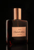 A dark glass bottle with a gold cap labeled "LUST | Oud Delice Chris Collins" encases a luxurious aphrodisiac perfume infused with sensual musks.