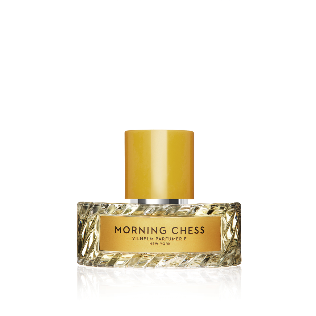 A Vilhelm Parfumerie "Morning Chess" perfume bottle, featuring a textured, rectangular design and a yellow cap, labeled "Vilhelm Parfumerie New York" and "Morning Chess," evokes the scent of bergamot mingling with hints of Tuscan leather.