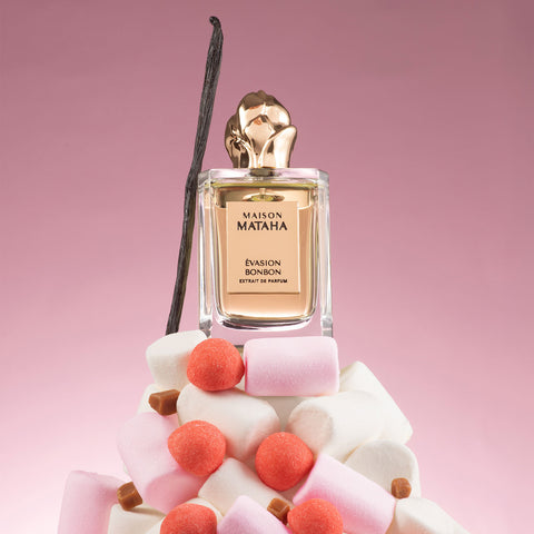 Evasion Bonbon perfume bottle with gold cap and pink wax candy pieces