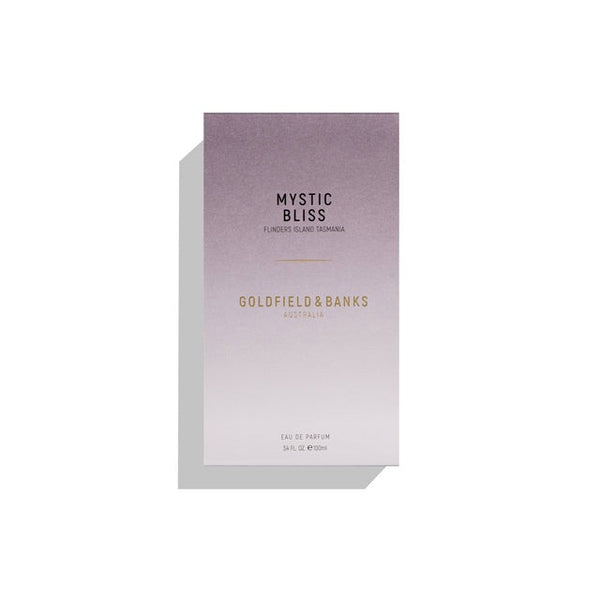 A rectangular perfume box labeled "Mystic Bliss" by Goldfield & Banks, showcasing a gradient design shifting from dark purple to light gray. The text "Flanders Island Tasmania" and "Eau de Parfum 50 ml e 1.7 fl. oz." is also printed, highlighting botanical essences of Australian Kunzea.