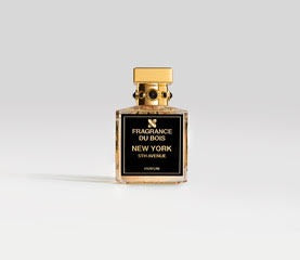 A bottle of New York 5th Avenue by Fragrance Du Bois, featuring a gold cap and black label on a plain background, embodies the essence of winter in NYC with its sweet floral and woody notes.