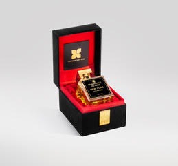 The New York 5th Avenue perfume by Fragrance Du Bois, encased in a black and gold bottle and exuding a sweet floral essence, is beautifully presented inside an open, black and red velvet-lined box against a grey background.