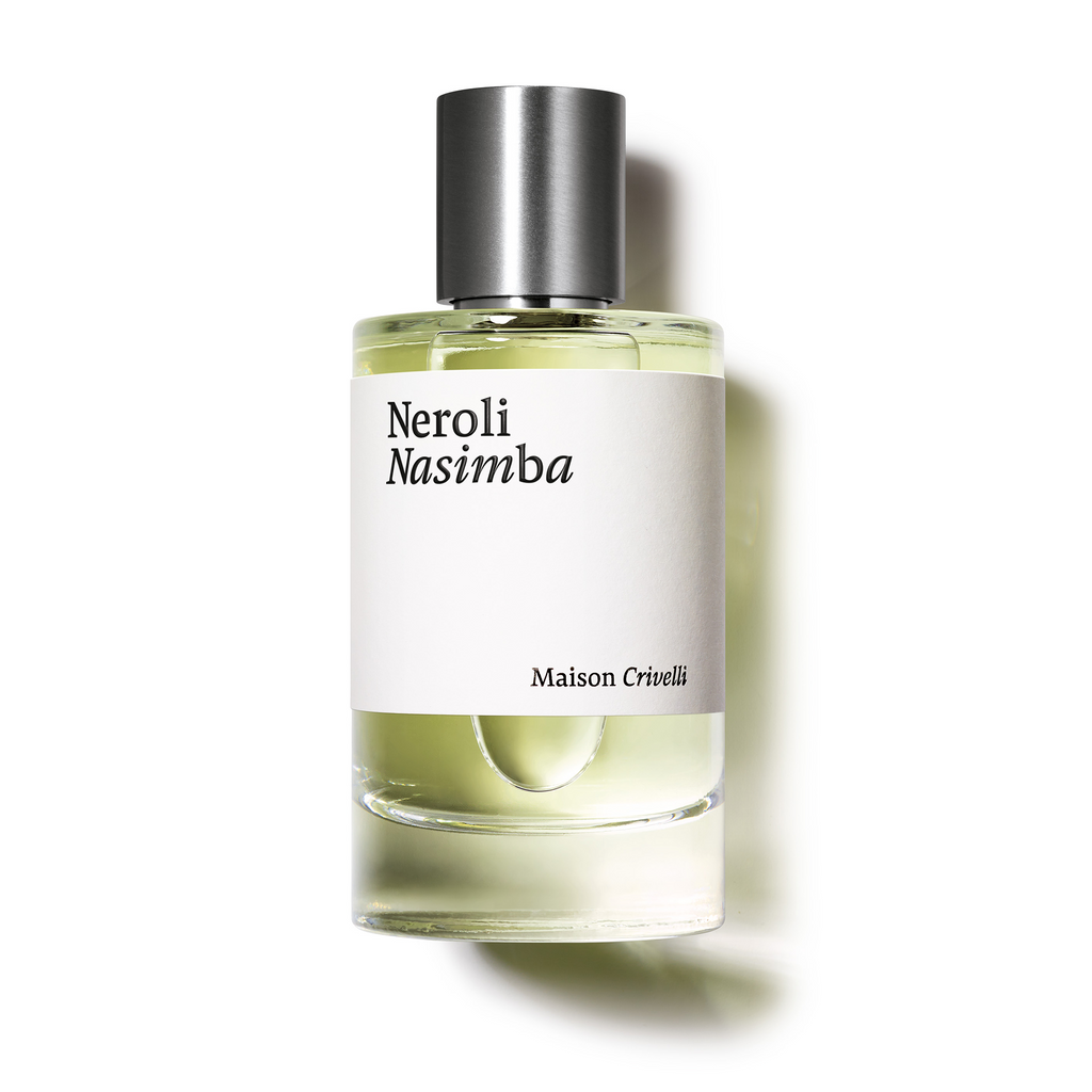 A clear glass bottle of Maison Crivelli's Neroli Nasimba perfume, showcasing a white label and silver cap. This floral leather eau de parfum is enriched with notes of neroli essential oil and orange blossom absolute.