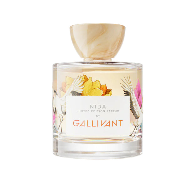 A bottle of NIDA by Gallivant Perfumes, inspired by the Baltic coastline, features a floral illustration on the label and a marbled, light-colored cap.