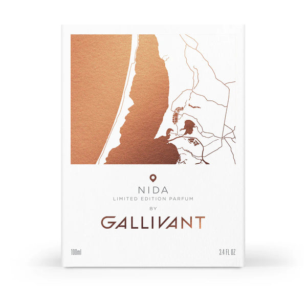 A white box with a bronze map design on its cover reads: "NIDA Limited Edition Parfum by Gallivant Perfumes," evoking the Baltic coastline. The box indicates the volume as 100ml (3.4 fl oz).