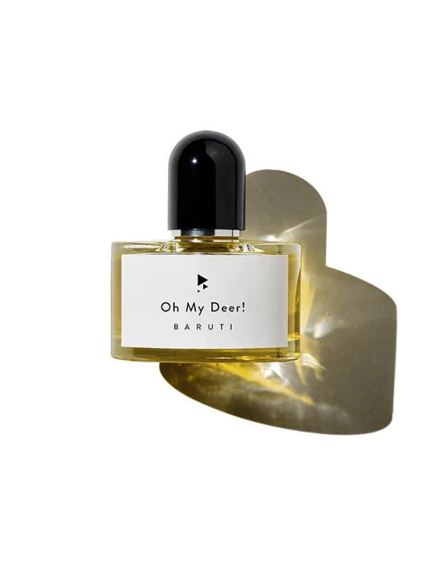 A perfume bottle labeled "Oh My Deer!" by Baruti, featuring a sensual musky eau de parfum with golden liquid inside, a black cap, and a reflective gold backdrop.