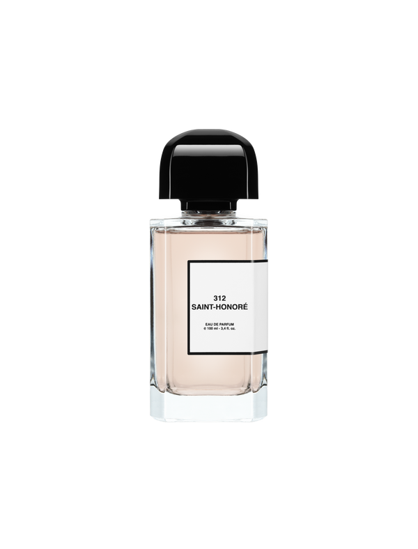 A clear glass perfume bottle with a black cap labeled "312 Saint-Honoré" by BDK Parfums and containing a light pink liquid, reminiscent of orange blossom.