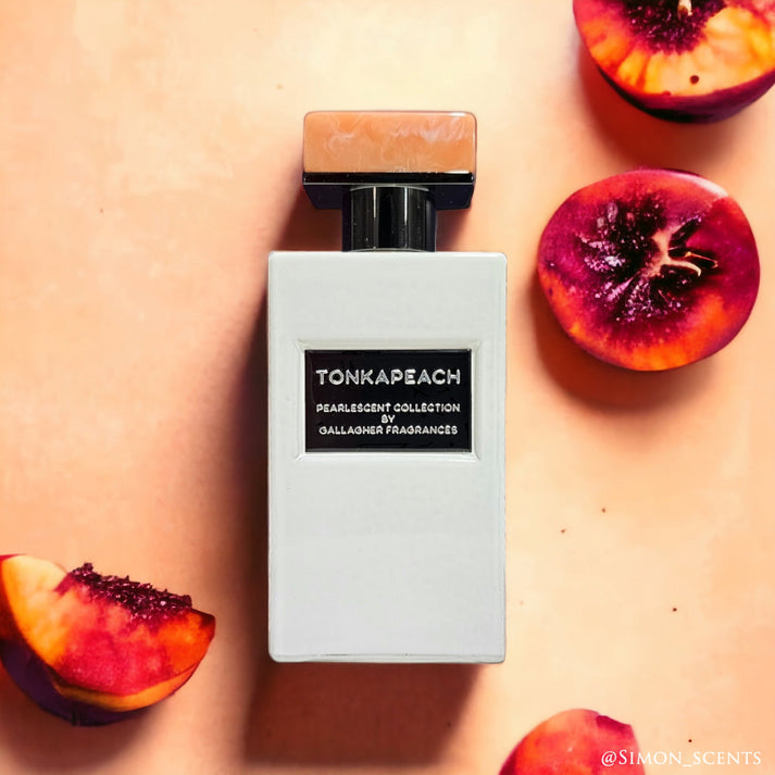 A white bottle of Tonkapeach perfume from the Pearlescent Parfums Collection is surrounded by sliced peaches on a pale peach background, evoking the warmth and sweetness of a fresh Peach Cobbler.