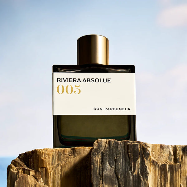 Gold-capped perfume bottle with white label '005' and Riviera Absolue