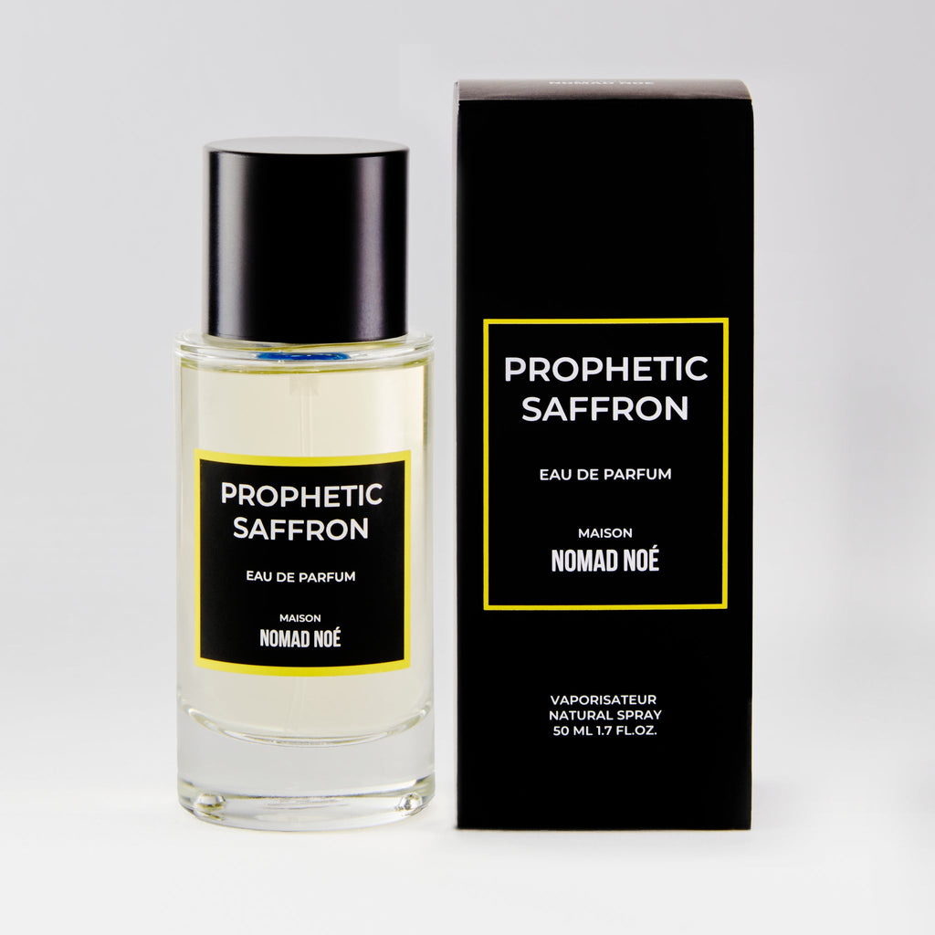 A 50 ml bottle of "Prophetic Saffron" eau de parfum by Nomad Noe, enriched with saffron essence, shown next to its black and yellow packaging.