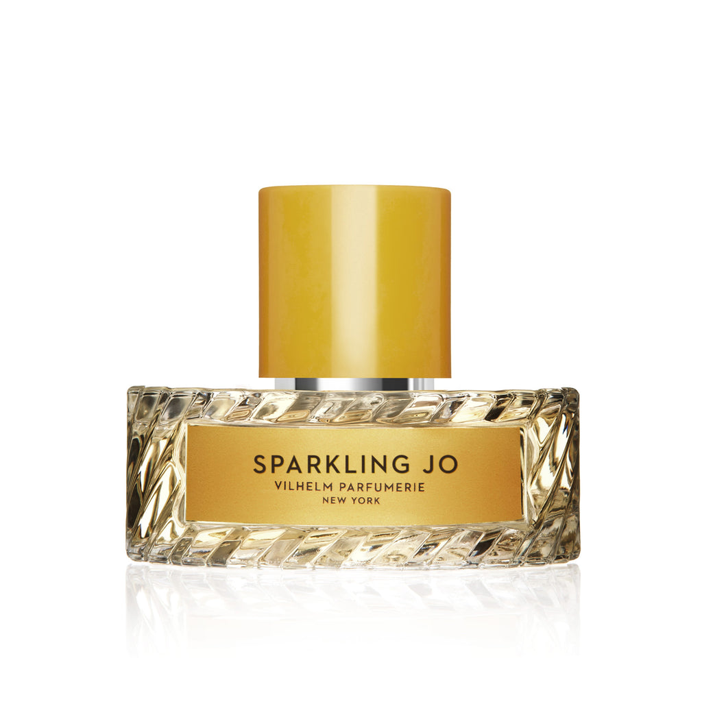 A perfume bottle labeled "Sparkling Jo" by Vilhelm Parfumerie, New York, featuring a luminous yellow cap and an intricately textured glass design.