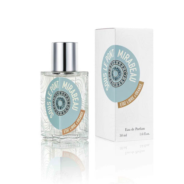 A bottle of "SOUS LE PONT MIRABEAU" Eau de Parfum by État Libre d'Orange, highlighted by delicate pink pepper notes, sits elegantly next to its white and turquoise box. The bottle contains 50 ml (1.6 fl oz) of this enchanting perfume, which also features hints of sandalwood.