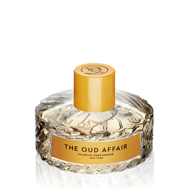 A bottle of **The Oud Affair** perfume by **Vilhelm Parfumerie**, featuring a yellow cap and a light amber liquid inside a textured glass bottle, with enticing hints of wild honey enhancing its allure.