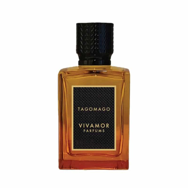 A rectangular bottle of Tagomago by VIVAMOR Parfums, containing an amber-colored liquid and featuring a black textured label, exudes a tropical fragrance perfect for a summer scent.