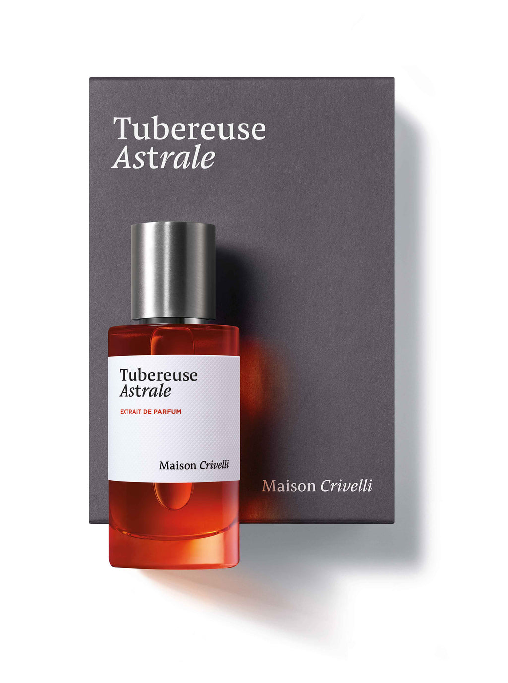 A bottle of Tubéreuse Astrale Extrait de Parfum by Maison Crivelli, crafted by Quentin Bisch, is placed in front of its matching box. The bottle features a silver cap and a label showcasing the perfume's name and brand.