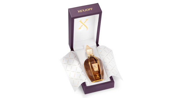 A bottle of Xerjoff Alexandria II Anniversary perfume in brown glass with a golden cap is displayed in an open purple box lined with branded white paper.