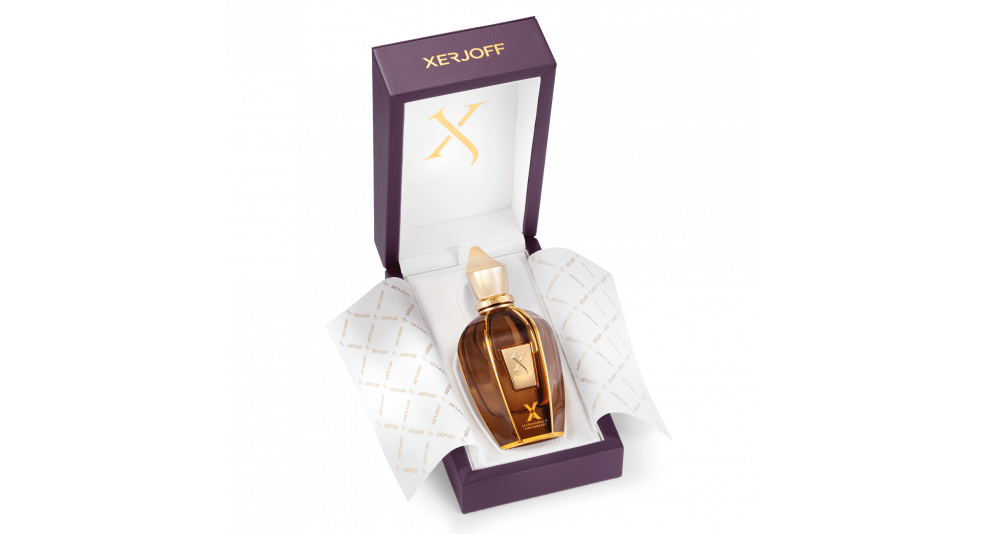 A bottle of Xerjoff Alexandria II Anniversary perfume in brown glass with a golden cap is displayed in an open purple box lined with branded white paper.