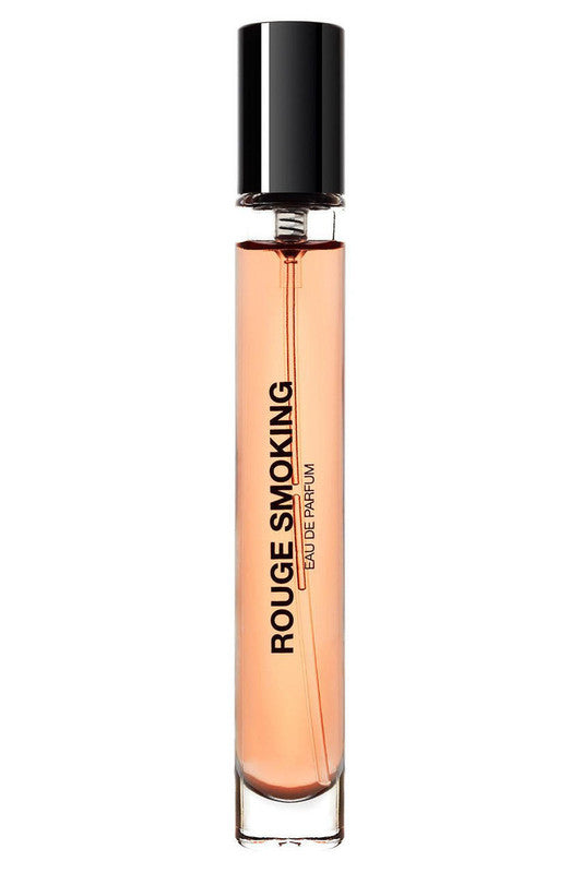 A slender, cylindrical perfume bottle labeled "Rouge Smoking" with a black cap and pinkish liquid inside exudes Parisian glam, enhanced by the subtle notes of Italian Bergamot.