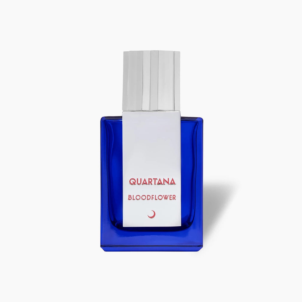 A rectangular, blue glass bottle of Parfums Quartana's Bloodflower perfume, featuring a white ribbed cap and red text on a white label, hints at the enigmatic blend within with notes of Blood Accord and Dark Rose.