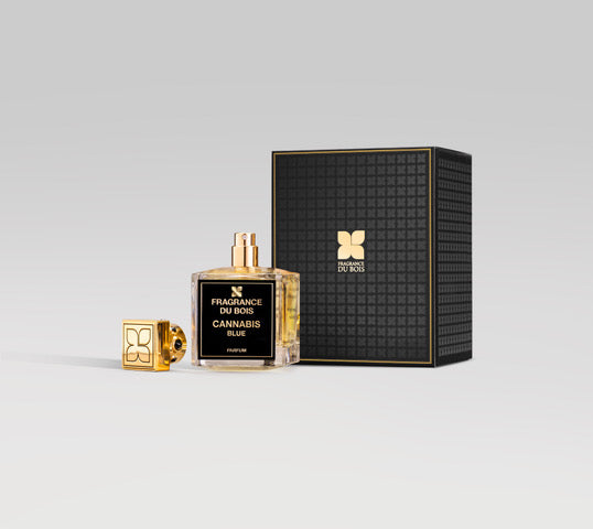 A clear bottle of Fragrance du Bois Cannabis Blue, infused with a unique Cannabis accord, features a gold cap and is displayed next to its luxurious black and gold box.