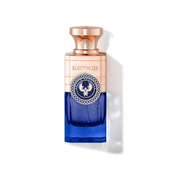 A rectangular perfume bottle with a rose gold cap and top half, transitioning to a blue base. The brand name "Electimuss Aquila Absolute" is printed on the upper part, featuring a circular emblem with an eagle. The scent, crafted by Julien Rasquinet, offers bright fresh fruity notes.