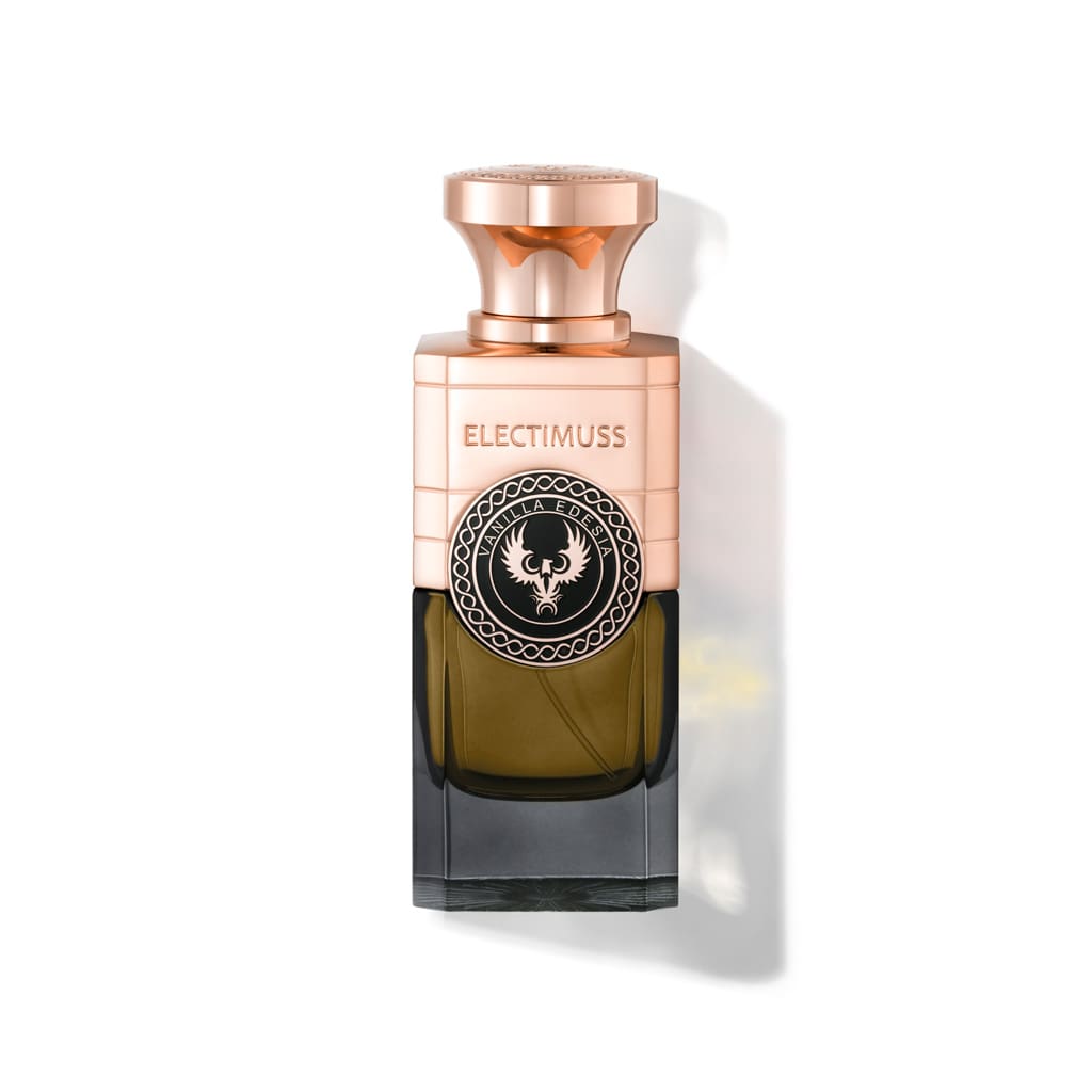 A bottle of Vanilla Edesia by Electimuss showcases a sophisticated blend of exotic spices, encased in a transparent green and copper design adorned with a decorative black emblem.