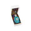 A blue perfume bottle with a gold cap, in a white box lined with colorful, patterned fabric reminiscent of a Mediterranean fruit basket, Erba Pura by Xerjoff.