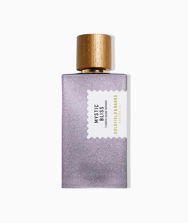 A bottle of Mystic Bliss perfume, designed with a sleek metallic purple body and an elegant golden cap. The label proudly displays "Mystic Bliss" by Goldfield & Banks and highlights its Australian origin. Infused with botanical essences of Australian Kunzea, this perfume offers an enchanting scent.