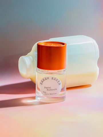 Scented perfume bottle with orange cap and clear glass body
