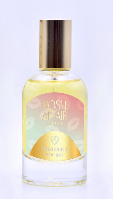 A bottle of Frederico Parfums' "Posh Affair" parfum, featuring a gold cap and a label with colored lips against a gradient background, captures the essence of fruity red florals.