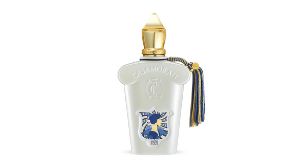 A white perfume bottle with a gold cap and blue tassel. The bottle displays the Casamorati label and a blue emblem featuring a black horse and rider, capturing the essence of Quattro Pizzi by Casamorati with its exquisite olfactory notes, perfect for a summer scent.