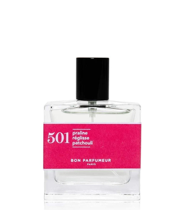 501 perfume bottle with black cap and pink label on clear glass