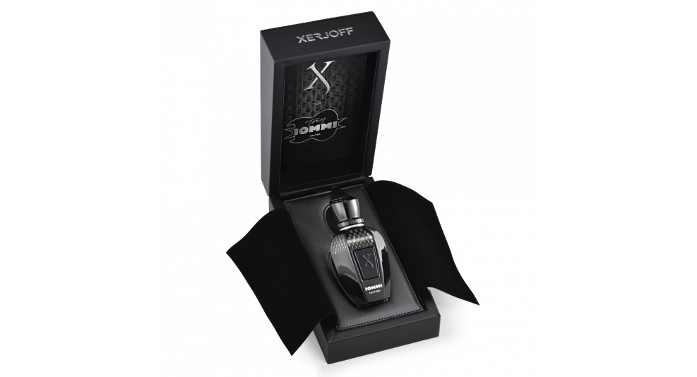 A sleek black bottle of Xerjoff Iommi DEIFIED perfume is displayed inside a black rectangular box with an open lid. The bottle features a silver cap and decorative patterns, exuding a sense of elegance akin to Tony Iommi's style.