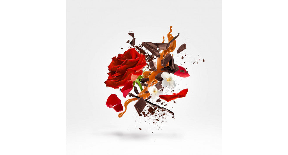 A digital artwork from the Xerjoff Via Cavour 1 collection showcases an explosion of red roses, white flowers, and pieces of chocolate and caramel against a white background.