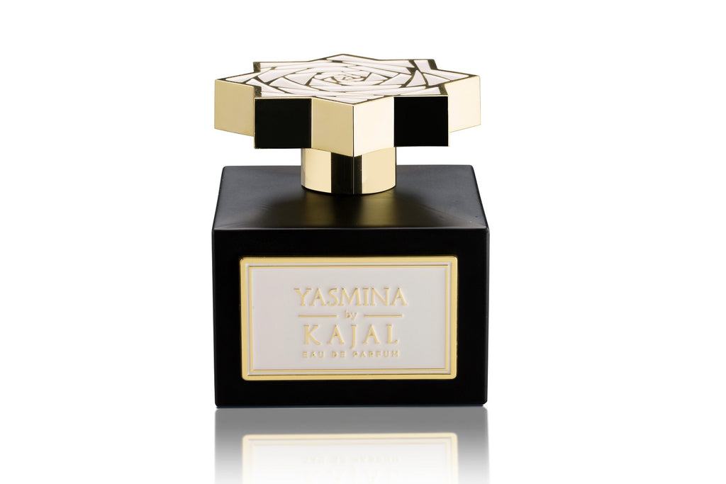 A black and gold perfume bottle with a star-shaped cap emanates an aura of strength. The label reads "Yasmina by Kajal - Wardé Collection," hinting at the enchanting scent of jasmine flowers within.