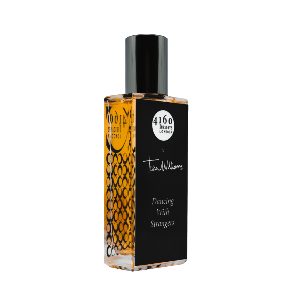A rectangular perfume bottle with a black label reading "4160Tuesdays - Dancing With Strangers." The bottle contains an amber-colored liquid, enveloped in delicate powdery notes and floral musk.
