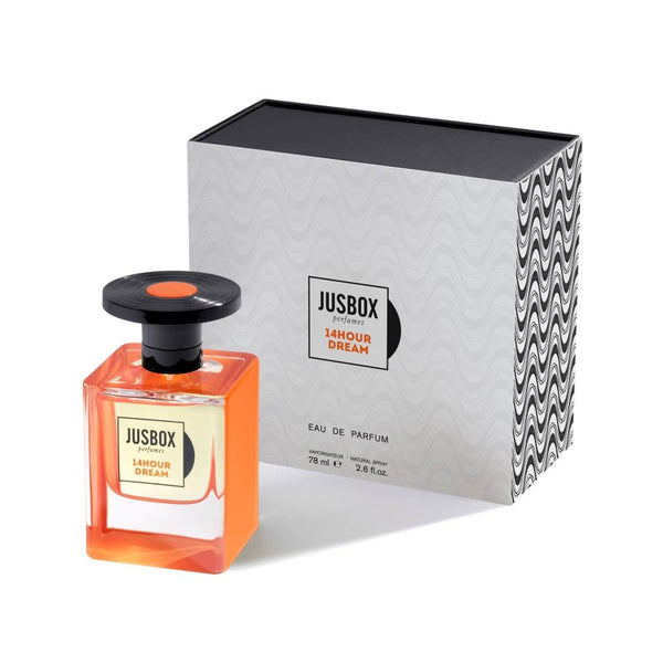 A 78 ml bottle of Jusbox 14Hour Dream sits in front of its packaging box. The perfume bottle is square-shaped with an orange liquid inside and a black-capped spray nozzle, reminiscent of the vibrant era of Pink Floyd and psychedelic rock.