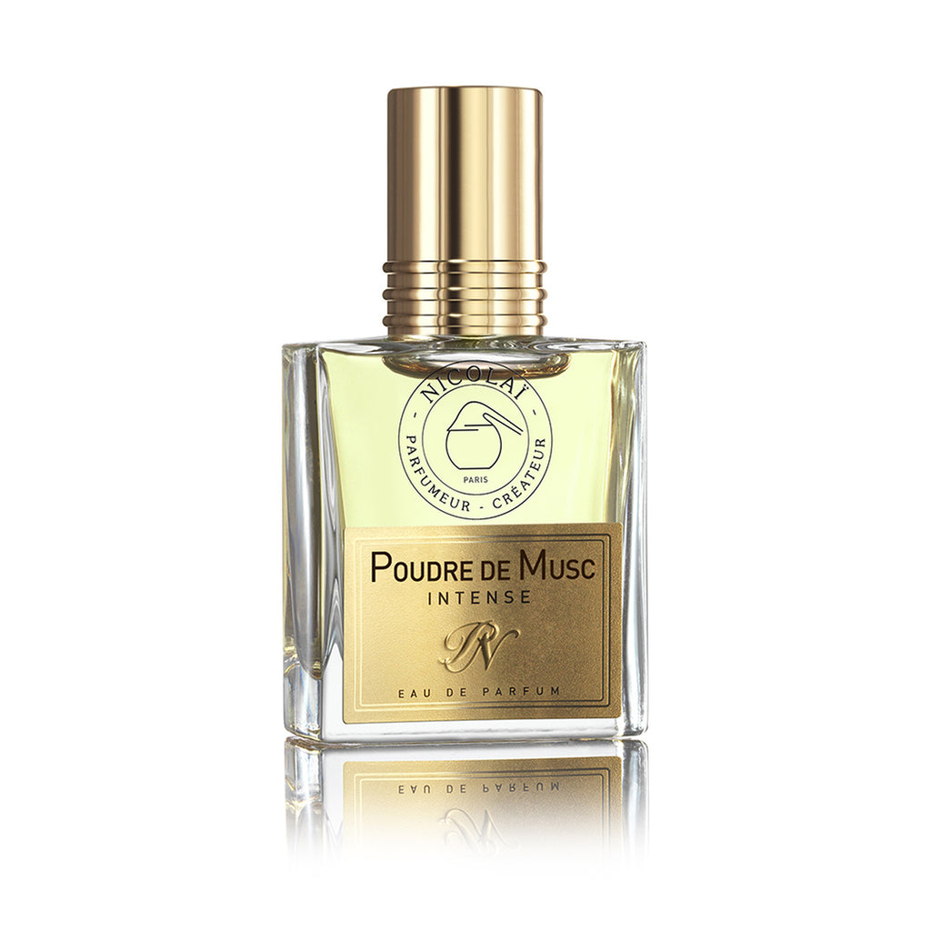A square glass bottle of Nicolaï Poudre De Musc Intense Eau de Parfum with a gold cap and label, containing a light amber liquid infused with captivating musk.