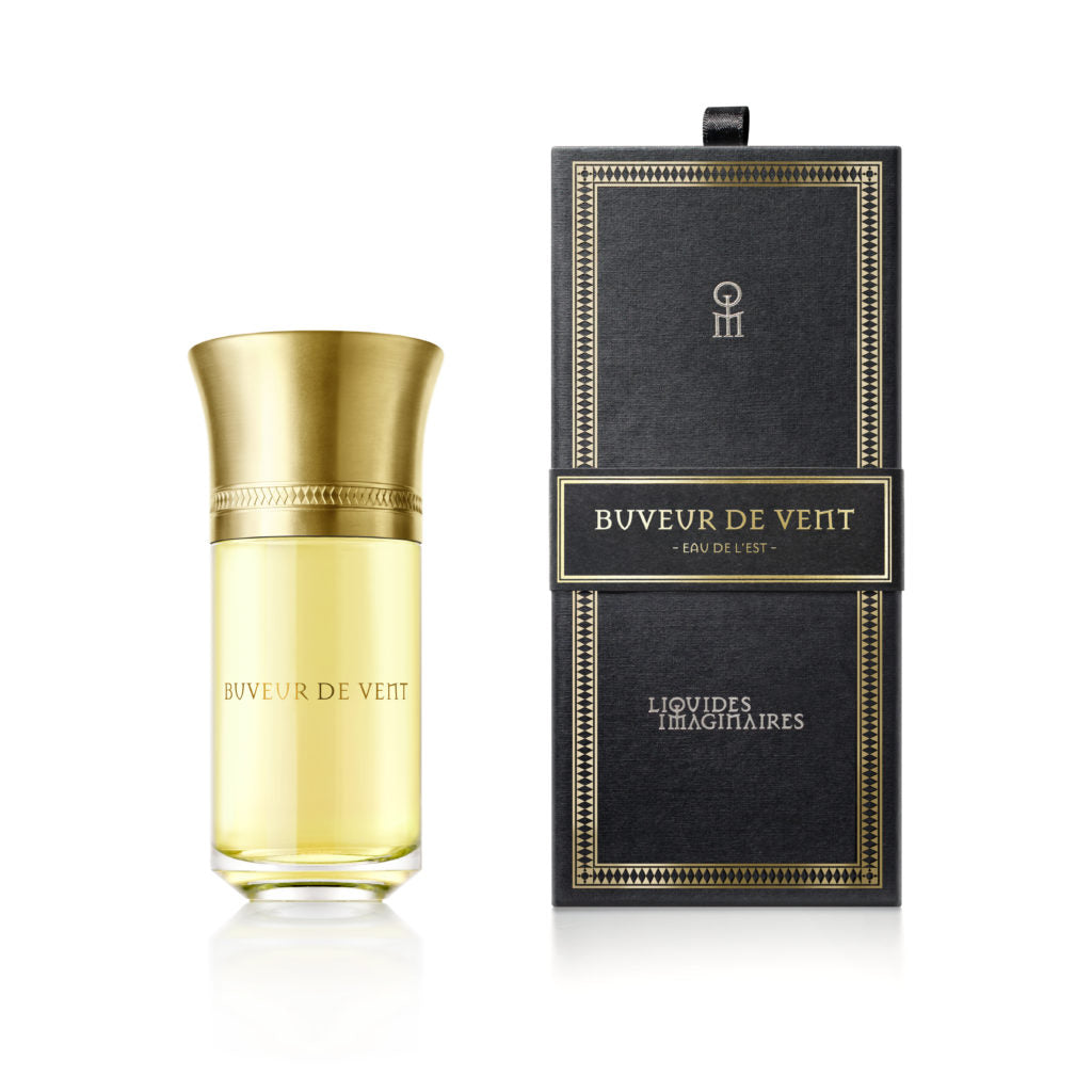 Perfume bottle with the "Buveur De Vent" label by Liquides Imaginaires, positioned next to its elegant black and gold box packaging, exuding notes of sandalwood.