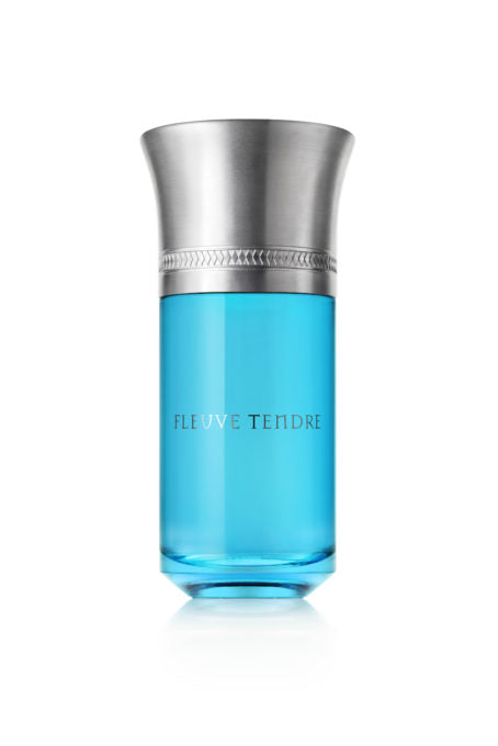 A cylindrical perfume bottle with a metallic silver cap and blue liquid, labeled "Fleuve Tendre," crafted by Sonia Constant for Liquides Imaginaires.