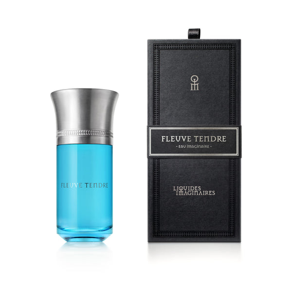 A blue perfume bottle labeled "Fleuve Tendre" by Liquides Imaginaires, crafted by Sonia Constant, stands next to a matching black rectangular box. The elegant bottle, which evokes the gentle flow of the Tendre River, features a metallic cap.