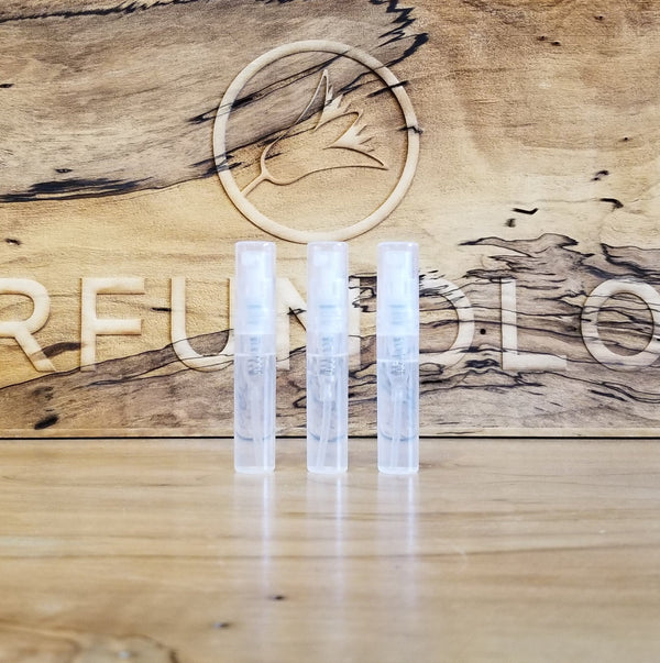 Three upright clear sample vials in transparent plastic holders